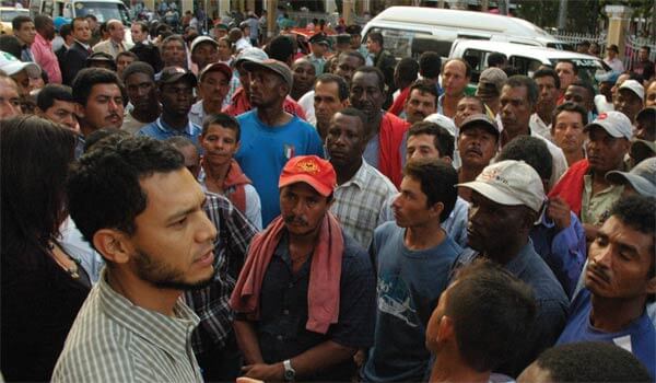 Juan Pablo Ochoa, left, addresses a crowd of cane cutters in Bua, Colombia after a court hearing related to their strike. "What is going on is a frame-up." Photo credit: Dawn Paley.