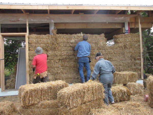 Volunteers building a wall as part of an August, 2009 strawbale building workshop. Creative Commons photo by CSLP.