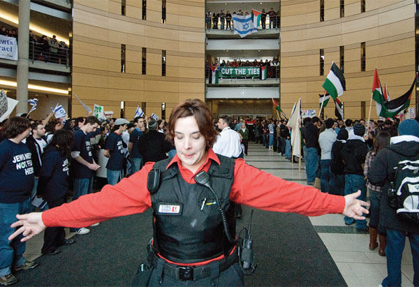 A security guard separates pro-Palestine and pro-Israel groups during York University’s Israeli Apartheid Week in February 2009. Photo by Jad yaghmour (Excalibur).