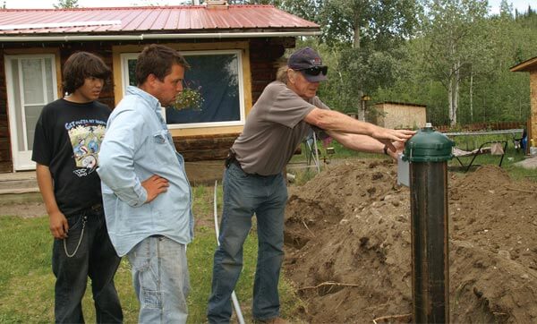 A Canadian Auto Workers volunteer helps install a new wellhead in Little Salmon Carmacks in 2007. Photo courtesy CAW.