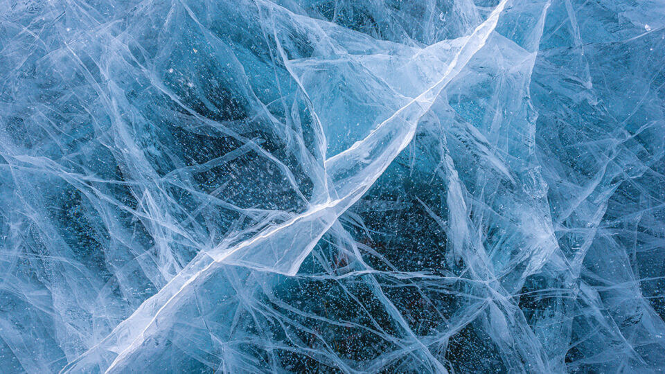 A close-up image of cracked blue ice.